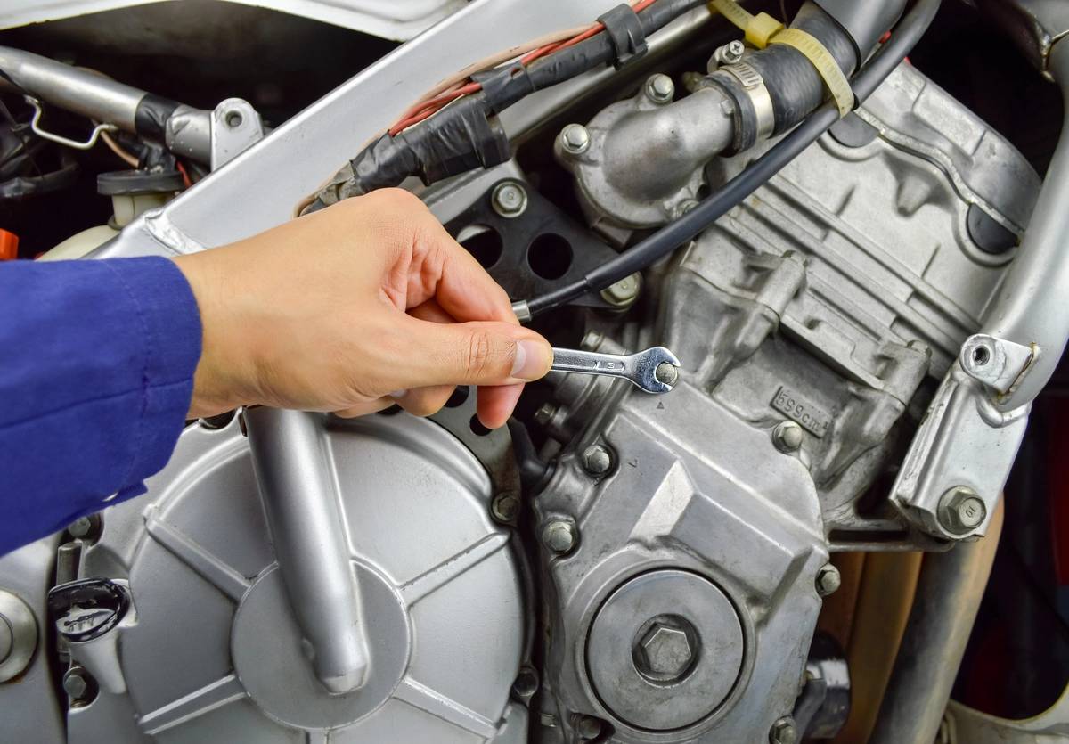 detail of hand of mechanic arranging the motorbike motor